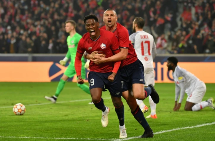 L'attaquant canadien de Lille, Jonathan David, est félicité par l'attaquant turc Burak Yilmaz, après avoir ouvert le score à domicile face à Salzbourg, lors de leur match de groupes de la Ligue des Champions, le 23 novembre 2021 au Stade Pierre-Mauroy
