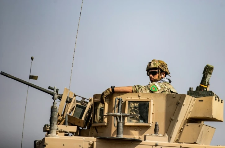 Un soldat portant un écusson de la milice kurde syrienne des YPG en haut d'un char dans la ville de Tal Tamr, le 20 octobre 2019.