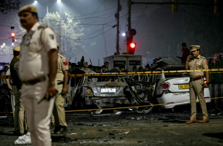 Des policiers inspectent des véhicules calcinés alors qu'ils évacuent le lieu de l'explosion près du Fort Rouge, dans le vieux quartier de Delhi, le 10 novembre 2025
