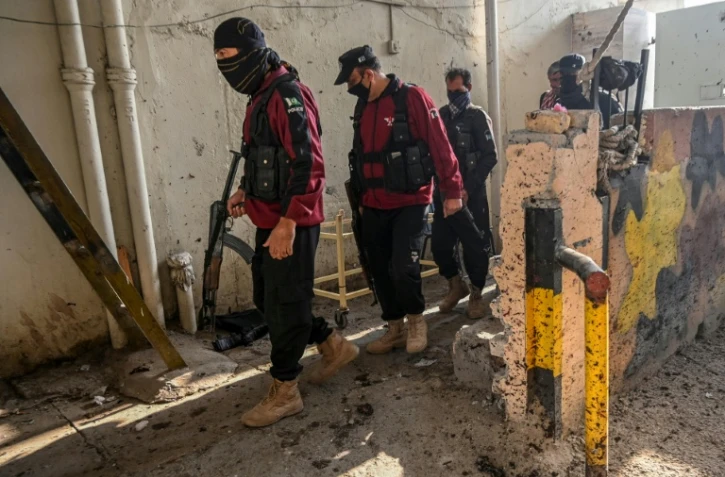 Des membres des services de sécurité examinent le site où a été commis un attentat-suicide à Peshawar, au Pakistan, le 24 novembre 2025