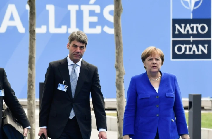 La chancelière allemande Angela Merkel arrive au siège de l'Otan à Bruxelles avec un collaborateur, le 11 juillet 2018.