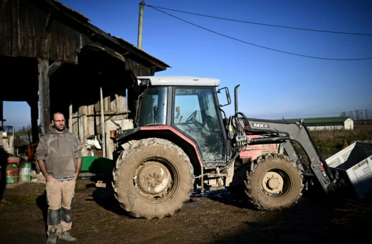 L'éleveur Jérôme Caze pose devant son tracteur dans son exploitation de Meilhan-sur-Garonne, dans le sud-ouest de la France, le 23 janvier 2025 