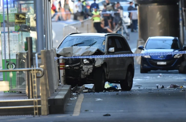 Un SUV blanc (g) accidenté sur la chaussée, après qu'une voiture a foncé sur des piétons, le 21 décembre 2017 à Melbourne, en Australie