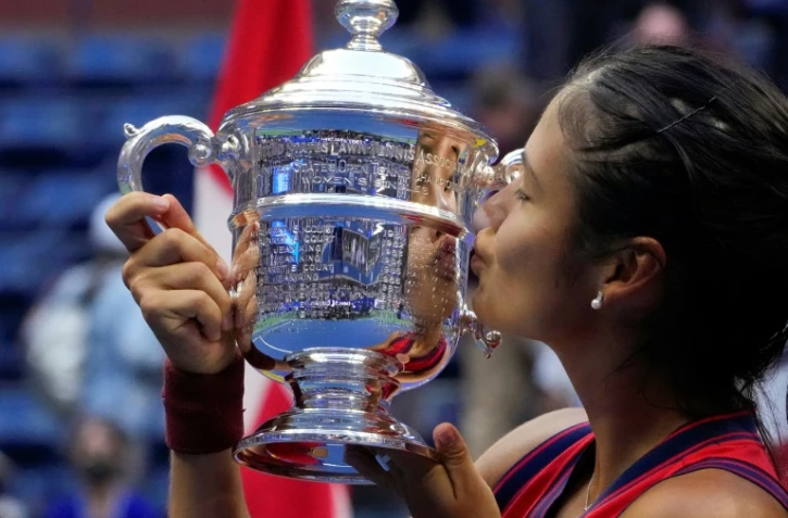 La Britannique Emma Raducanu embrasse le trophée après savictoire dans la finale du simple dames de l'US Open contre la Canadienne Leylah Fernandez au Centre natinal de tennis Billie Jean King à New York, le 11 septembre 2021
