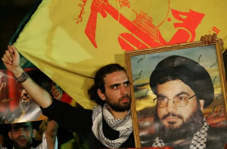 Des hommes brandissent des drapeaux du Hezbollah et des portraits du chef du groupe Hassan Nasrallah dans une banlieue sud de Beyrouth le 11 septembre 2006