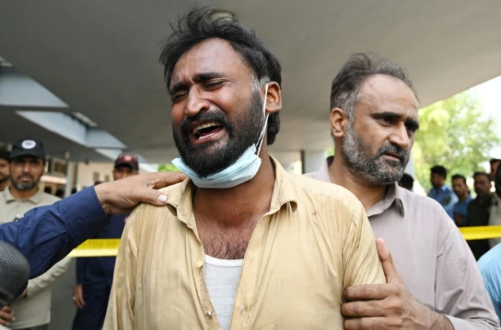 Un père pleure après la mort de son enfant à la suite d'un incendie devant le service de santé maternelle et infantile de l'hôpital PIMS, à Islamabad, le 26 août 2026. L'incendie a coûté la vie à 14 nourrissons.