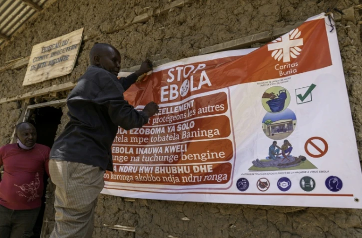 Un homme accroche une affiche de sensibilisation dans la lutte contre le virus Ebola, le 28 mai 2026 à Bunia, dans l'est de la République démocratique du Congo (RDC)