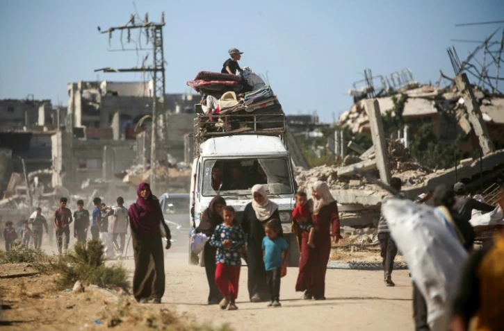 Des Palestiniens déplacés retournent chez eux, le 14 octobre 2025 dans la zone d'al-Zahra dans la bande de Gaza