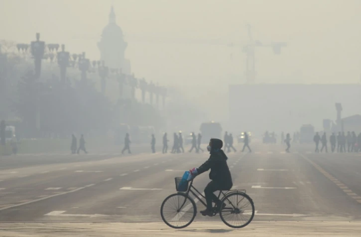 Un cycliste sous un nuage de pollution à Pékin, le 21 décembre 2015