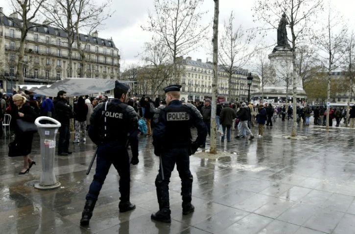 Des policiers regardent quelques centaines de personnes se rassemblaient place de la République pour une assemblée générale du mouvement "Nuit debout", à Paris le 11 avril 2016