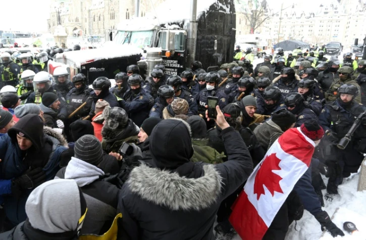 Un cordon de policier encercle des manifestants à Ottawa, au Canada le 19 février 2022