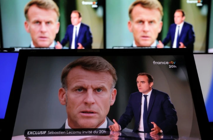 Le Premier ministre démissionnaire Sébastien Lecornu sur le plateau de France 2 avec une photo du président Emmanuel Macron en arrière-plan, le 8 octobre 2025