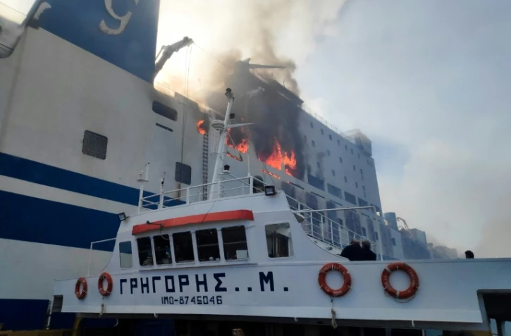 Un bateau des pompiers grecs s'approche du ferry italien Euroferry Olympia, n feu au large de l'île grec de Corfou, le 18 février 2022