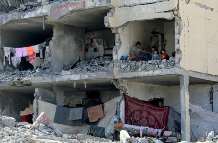 Une famille palestinienne dans une pièce détruite par une frappe israélienne à Rafah, dans le sud de la bande de Gaza, le 22 mai 2024