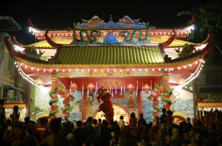 Des gens regardent une danse du Lion devant un temple pour fêter le Nouvel An chinois, le 4 février 2019 à Medan (Indonésie)