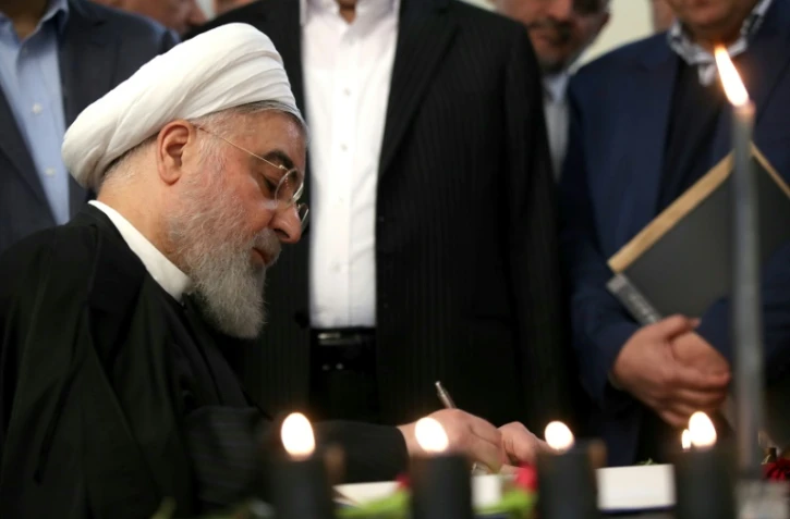Photo transmise par la présidence iranienne montrant le président iranien Hassan Rohani signant le registre des noms des victimes du crash d'un avion ukrainien, à Téhéran, le 15 janvier 2020