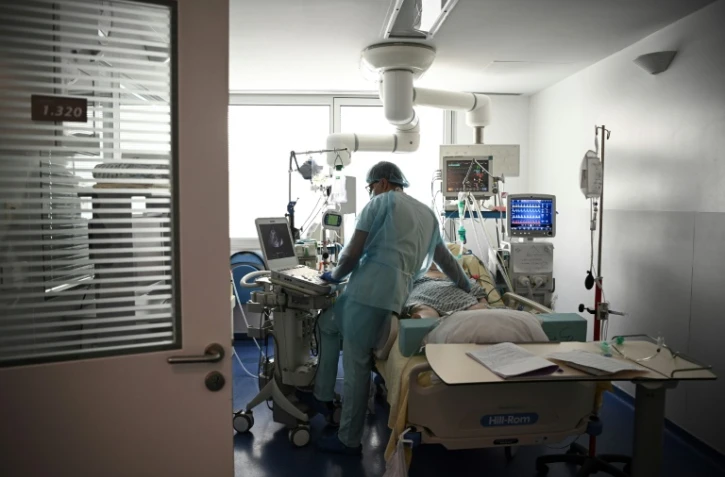 Un soignant s'occupe d'un patient infecté par le Covid-19 dans l'unité des soins intensifs de l'hôpital européen Georges-Pompidou à Paris, le 6 avril 2021
