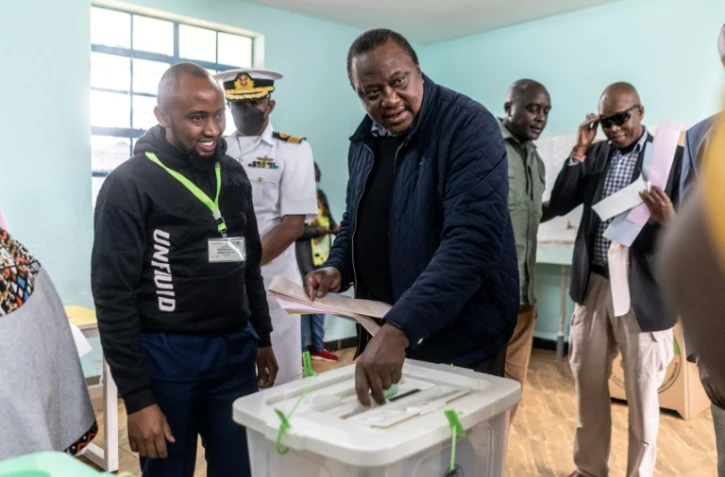 Le président kényan Uhuru Kenyatta dépose son bulletin de vote à l'école primaire Mutomo, lors des élections générales du Kenya à Kiambu, le 9 août 2022
