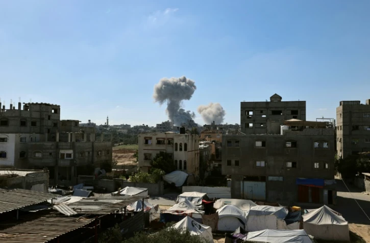 De la fumée s'élève en arrière-plan lors d'une frappe israélienne dans le centre de la bande de Gaza, le 29 mai 2025