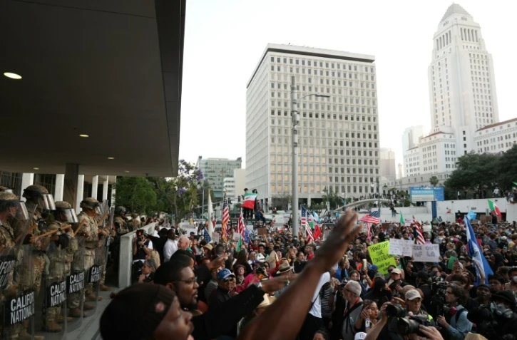 Une manifestation à Los Angeles, le 10 juin 2025, encadrée par la Garde nationale, alors que le couvre-feu à 20H mis en place par la maire de la ville vient d'entrer en vigueur