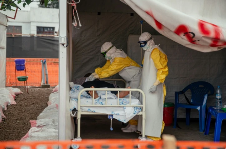 Des membres de Médecins Sans Frontières (MSF), en combinaison de protection, dans la zone d'isolement pour les patients atteints du virus Ebola au Centre de traitement Ebola (CTE) de Munigi, le 2 juin 2026 en RDC