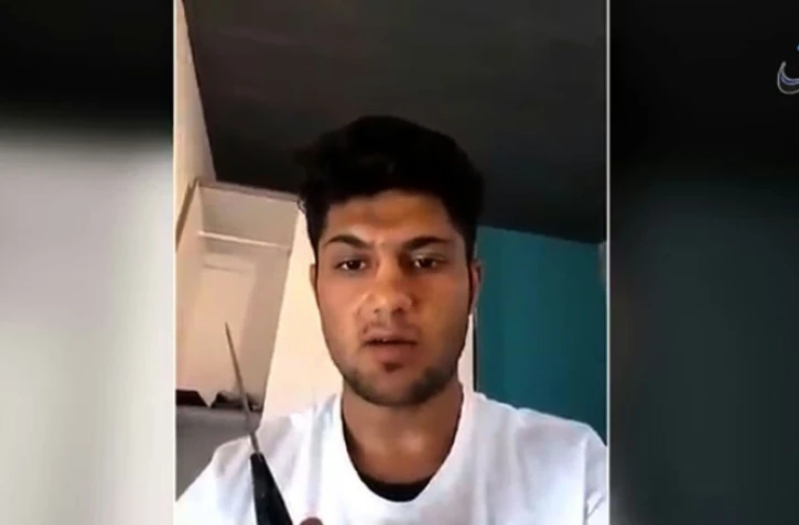 Capture d'écran d'une vidéo diffusée le 19 juillet 2016 par l'agence Amaq liée au groupe EI montrant Mohammed Riyadh, un couteau à la main, se présentant comme un "soldat du califat" et annonçant qu'il va commettre une "opération" en Allemagne