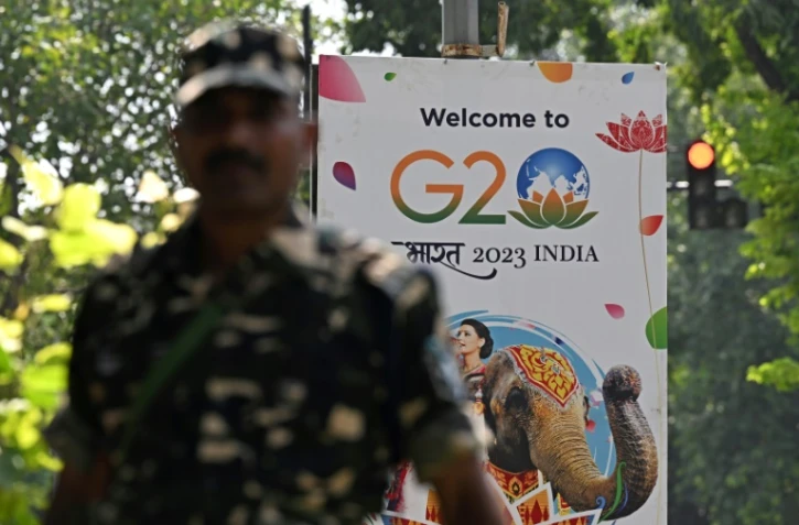 Un agent de sécurité monte la garde à côté d'une pancarte installée dans une rue de New Delhi avant le sommet de deux jours du G20, le 5 septembre 2023