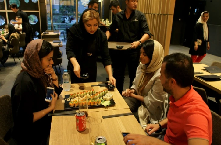 Des clients iraniens servis dans un restaurant d'une chaîne française de sushis dans le nord de Téhéran, le 16 juillet 2017 