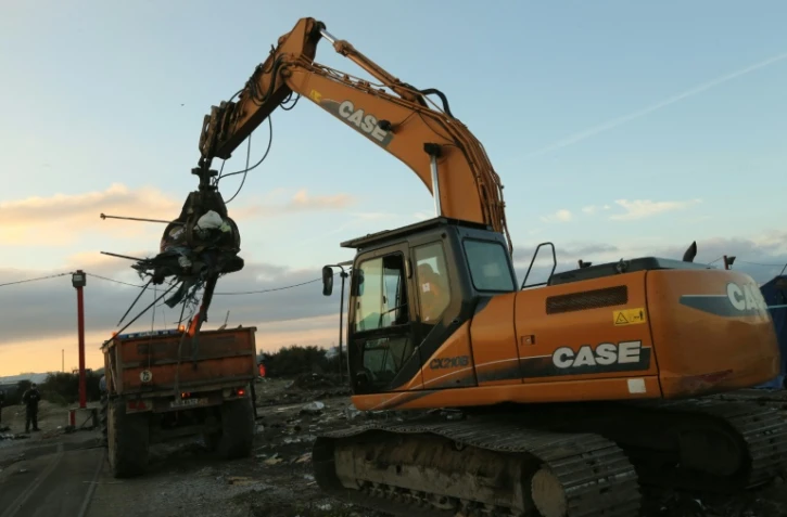 Une pelleteuse démantèle une baraque dans le camp de migrants de Calais, le 28 octobre 2016