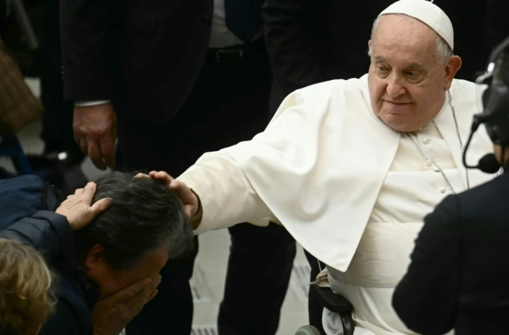 Le pape François touche la tête d'un homme, le 14 décembre 2024 à la salle Paul-VI au Vatican