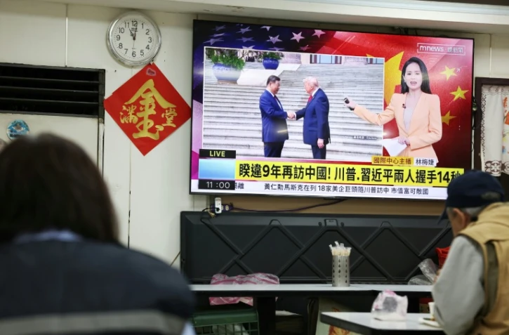 Une télévision diffuse un reportage dans un restaurant de Taipei, le 14 mai 2026, à Taïwan, montrant la rencontre entre le président américain Donald Trump et le président chinois Xi Jinping à Pékin