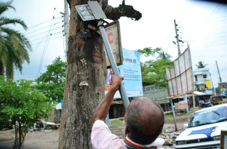 Ohid Sarder, 53 ans, nettoie les arbres des clous et pieux qui les encombrent, le 13 octobre 2018 Ă Jessore au Bangladesh
