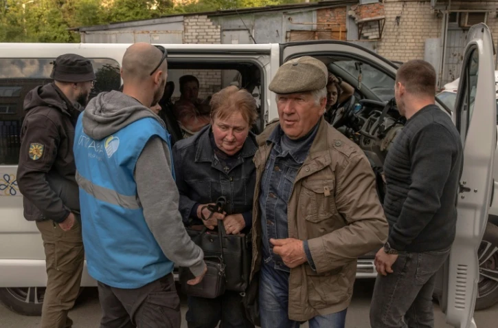 Des civils ukrainiens de la localité de Vovchansk arrivent à un point d'évacuation à Kharkiv, dans le nord-est du pays, le 11 mai 2024