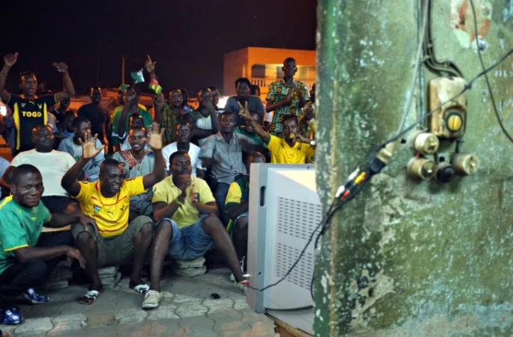 Des supporters togolais suivent sur une télévision en plein air le quart de finale de la CAN contre le Burkina Faso, le 3 février 2013 à Lomé