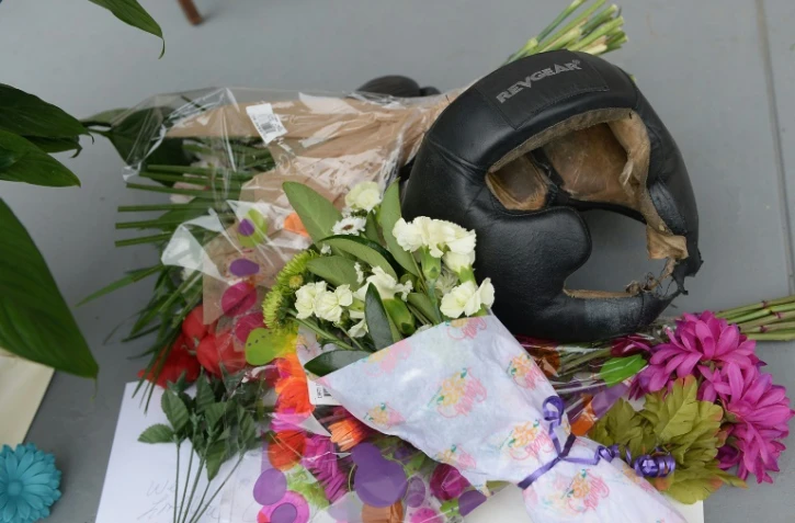 Un casque de boxe, des fleurs sont deposés comme des souvenirs, le 4 juin 2016 devant la maison où a grandi Mohamed Ali à Louisville