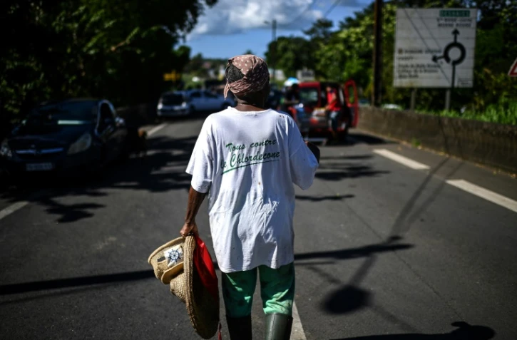 Une femme porte un t-shirt "Tous contre le chlordécone" près d'un barrage routier à La Boucan à Sainte-Rose, à la Guadeloupe, le 29 novembre 2021