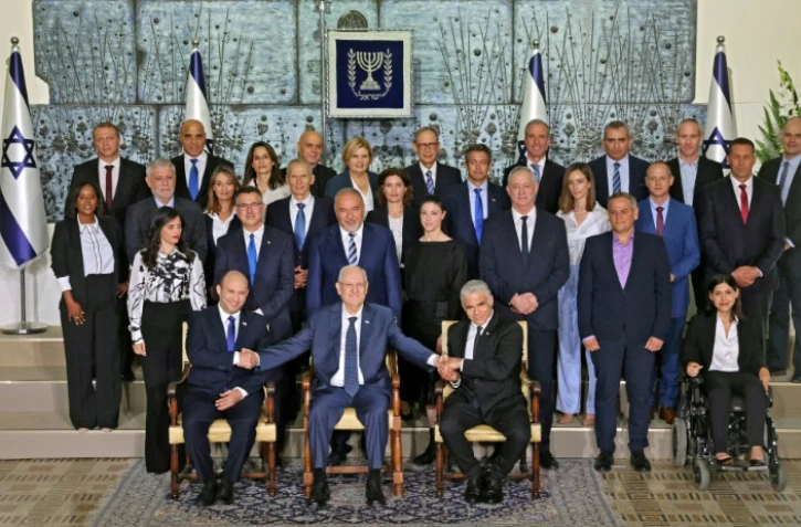 Le nouveau gouvernement israélien avec le président Reuvin Rivlin (c), le Premier ministre Naftali Bennett (g) et le ministre des Affaires étrangères Yaïr Lapid (d), à Jérusalem le 14 juin 2021