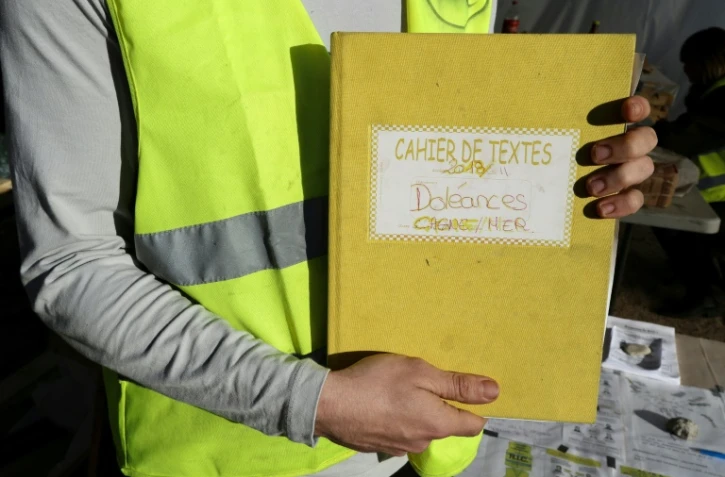 Un "gilet jaune" montre le cahier de doléances qu'il présente sur un rond-point à Cagnes-sur-mer, le 20 décembre 2018