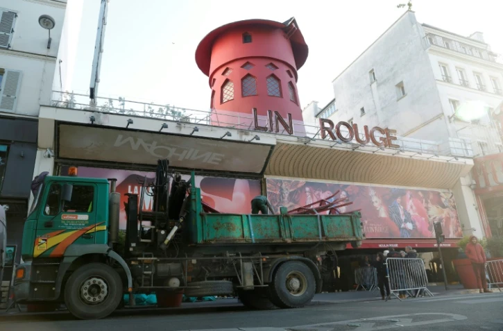 Des ouvriers sécurisent la zone devant le Moulin Rouge à Paris après que ses ailes et des lettres de la façade sont tombées dans la nuit sans faire de blessés, le 25 avril 2024