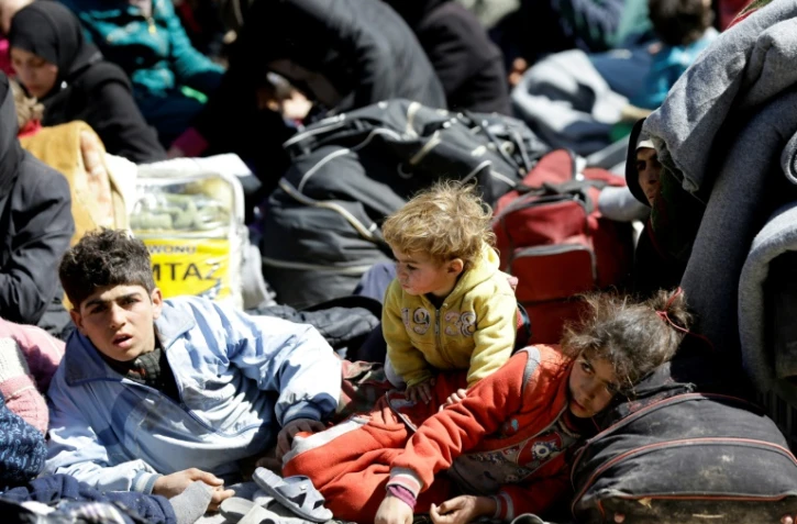 Des Syriens qui ont fui un secteur rebelle de la Ghouta orientale sont regroupés dans une école à Adra, dans une zone tenue par le gouvernement au nord-est de Damas, le 16 mars 2018
Syrian civilians, evacuated from rebel-held areas in the Eastern Ghouta, gather at a school in the regime-controlled Adra district, on the northeastern outskirts of the capital Damascus on March 16, 2018.On the edge of Ghouta, a sprawling semi-rural area within mortar range of central Damascus, hundreds of civilians were still streaming out of destroyed towns, carrying scant belongings in bags and bundles.