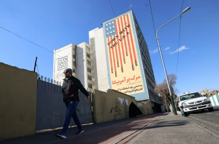 Un Iranien passe devant une immense fresque anti-américaine peinte sur un bâtiment dans la capitale iranienne, Téhéran, le 31 janvier 2026