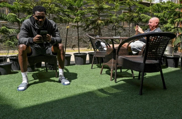 Le Nigérian Enyinnaya Loveday et l'entraîneur-adjoint écossais du Real Cachemire Jimmy Lindsay à la terrasse d'un restaurant d'hôtel le 11 avril 2020, pendant le confinement imposé par les autorités indiennes