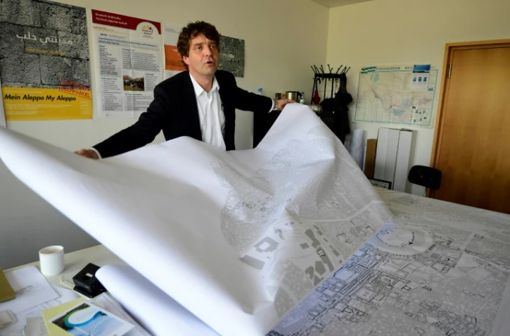 L'urbaniste Christoph Wessling montre la carte de la ville syrienne d'Alep, détruite par la guerre, le 17 mai 2017 à l'université de Cottbus, en Allemagne