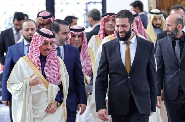 ePhoto fournie par l'agence syrienne Sana, le 24 janvier 2025, du nouveau dirigeant syrien Ahmad al-Chareh (d) accueillant le ministre saoudien des Affaires étrangères Fayçal ben Farhane à Damas