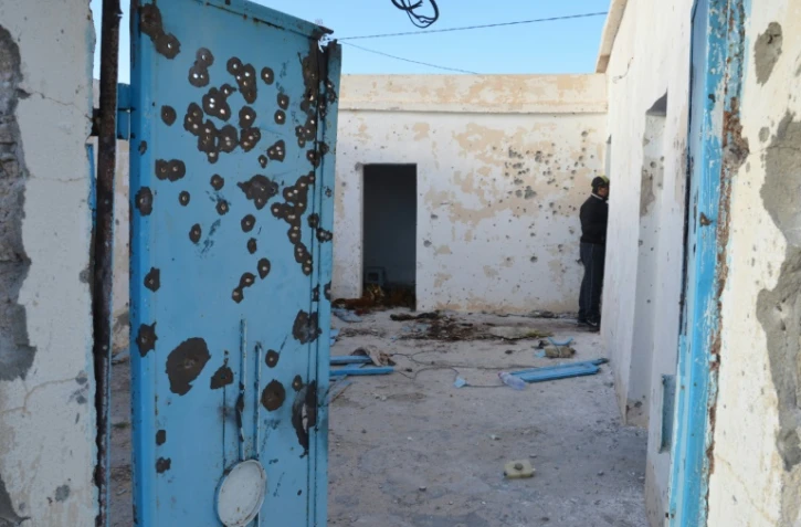 Un homme inspecte une maison à Benniri, au sud de la ville tunisienne de Ben Guerdane théâtre d'accrochages entre jihadistes et militaires, le 9 mars 2016