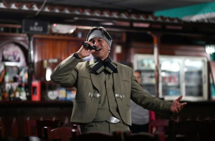 L'infirmier vénézuélien Edgar Fernandez, en costume de mariachi, chante dans un bar-restaurant d'El Junquito, près de Caracas, le 24 août 2019
