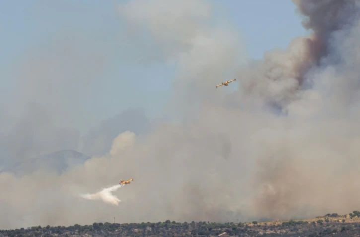 Des avions de lutte contre les incendies Canadair de l'armée de l'air espagnole larguent de l'eau sur un feu de forêt près de San Martín de Valdeiglesias, à l'ouest de Madrid, le 24 juillet 2026.
