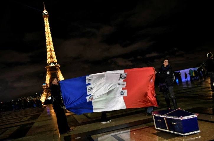 Des "policiers en colère" tiennent le drapeau français et posent près d'un cercueil représentant les fonctionnaires de police décédés, Esplanade du Trocadéro à Paris, 12 mars 2019