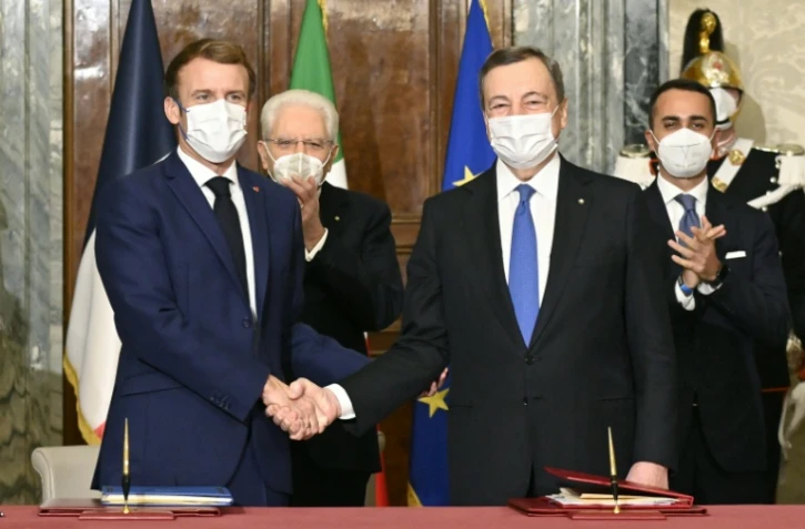 Au premier plan : Le président français Emmanuel Macron serre la main du Premier ministre italien Mario Draghi après la signature d'un traité bilatéral, le 26 novembre 2021 à Rome