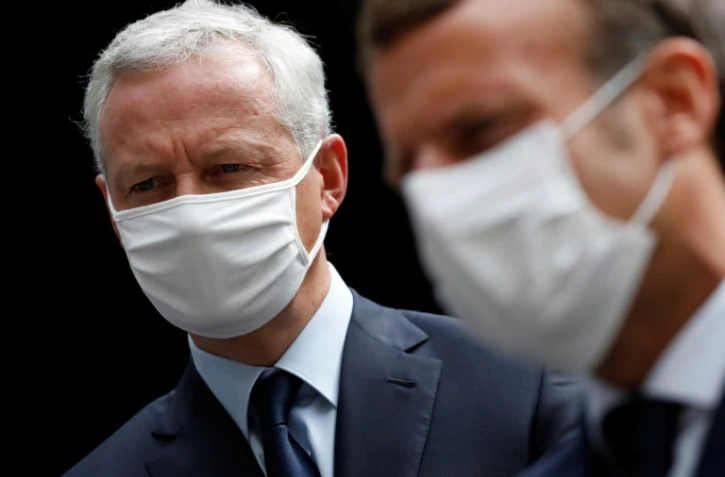 Le président français Emmanuel Macron (droite), et le ministre de l'Economie et des Finances Bruno Le Maire, s'entretiennent avec des employés d'une usine du groupe pharmaceutique Seqens, à Villeneuve-la-Garenne, près de Paris, le 28 août 2020